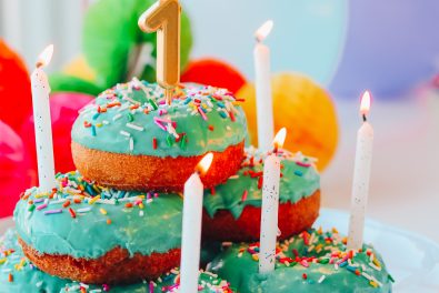 stack of green frosted doughnuts with first birthday candle